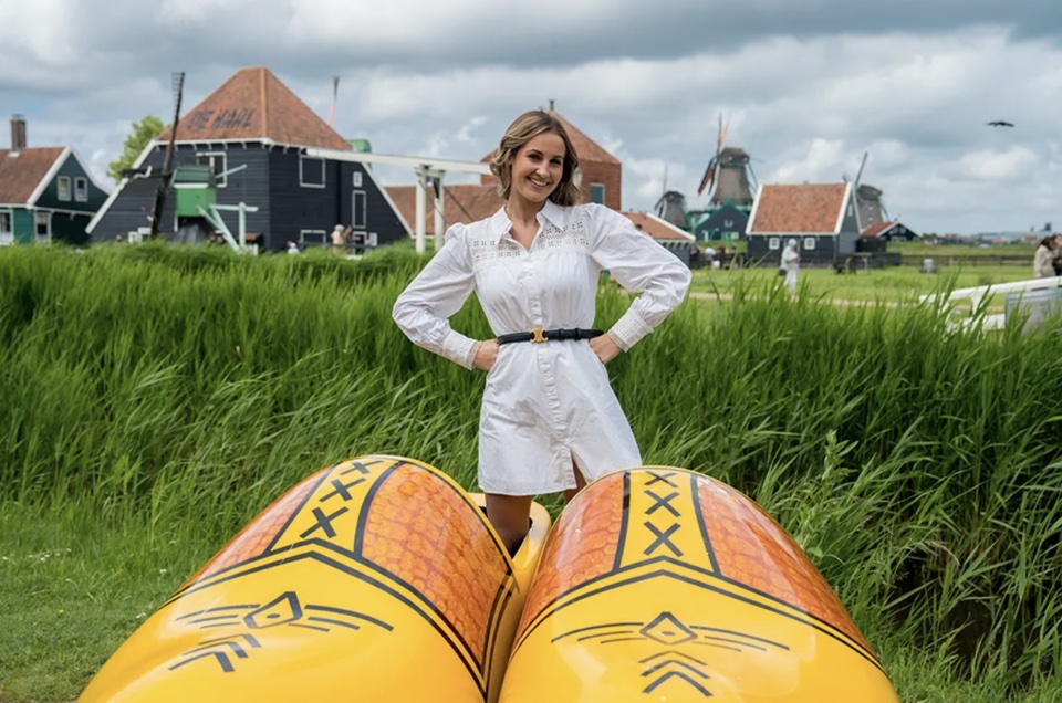 De oprichter van klomp.audio, staand achter twee reuzenklompen op de Zaanse Schans